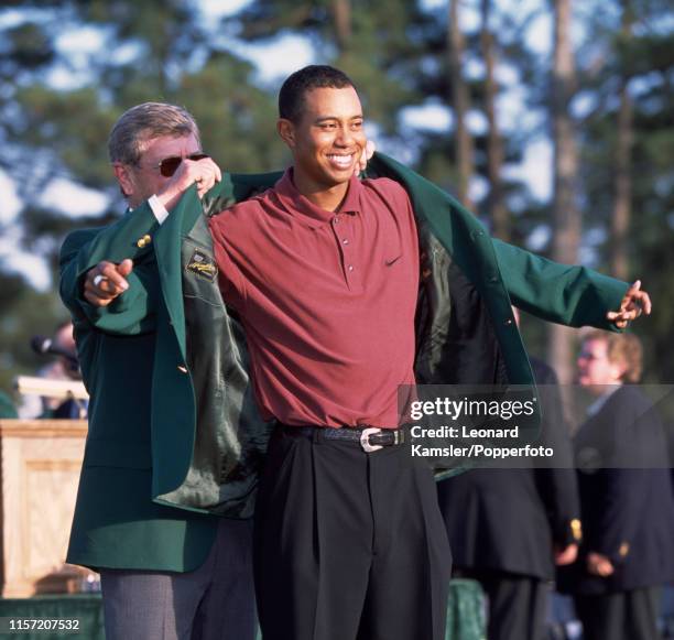 Tiger Woods of the USA is presented with his Green Jacket by the Tournament chairman Hootie Johnson after Woods' 3rd victory in the US Masters Golf...