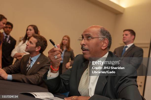 Profile view of former politicians Michael Steele and Aaron Schock, speaking with attendees following a Foreign Affairs Symposium at the Johns...