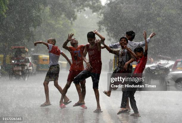 Boys seen dancing during heavy rainfall near Ramlila Maidan on July 22, 2019 in New Delhi, India. Heavy rains lashed parts of the national capital...