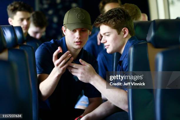 Jack Hughes and Cole Caufield of the United States ride the bus to the 2019 NHL Draft Top Prospects media availability at the Marina on June 20, 2019...