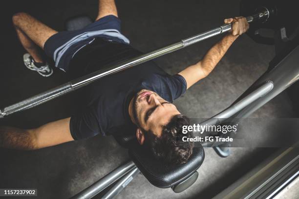 junger mann bei bankdrücken - bench press stock-fotos und bilder