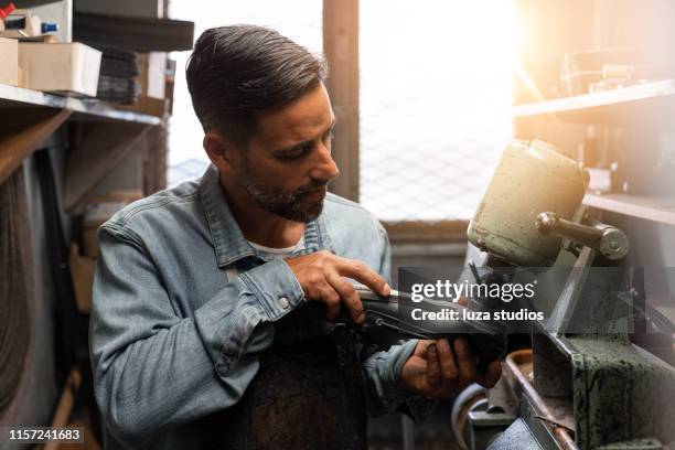 kleine ondernemer in zijn atelier - shoe repair stockfoto's en -beelden