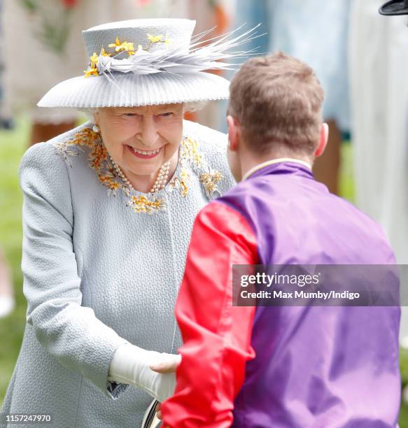 Queen Elizabeth II talks with jockey James McDonald before he rides her horse 'Eightsome Reel' in The Hampton Court Stakes on day three, Ladies Day,...