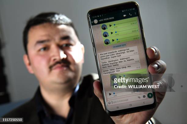 This photo taken on July 6, 2019 shows 32-year-old Melbourne-based Uighur refugee Shir Muhammad Hasan displaying messages on his phone at his...