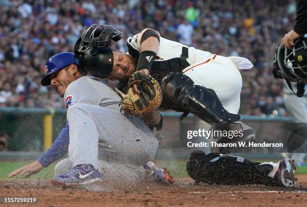 Anthony Rizzo of the Chicago Cubs scores while colliding with catcher Stephen Vogt of the San Francisco Giants in the top of the fourth inning at...