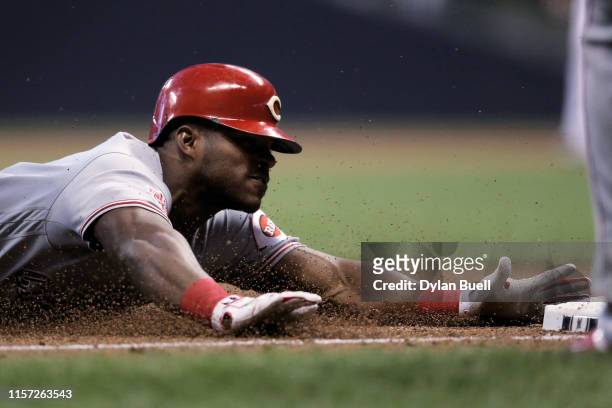 Yasiel Puig of the Cincinnati Reds slides into third base for a triple in the fifth inning against the Milwaukee Brewers at Miller Park on June 20,...