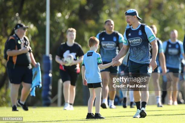 Damien Cook of New South Wales greets a young boy on arrival during a New South Wales Blues State of Origin training session at Hale School on June...