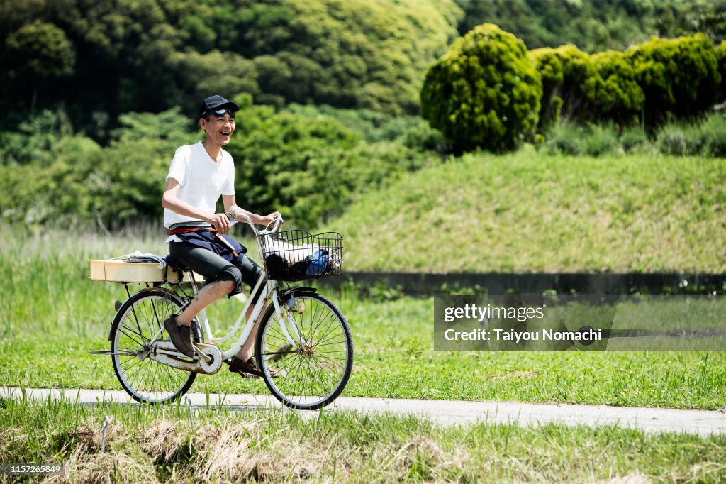 A man who runs by bicycle on a country road