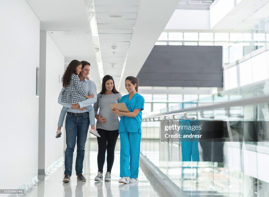 Happy family taking to a nurse at the hospital