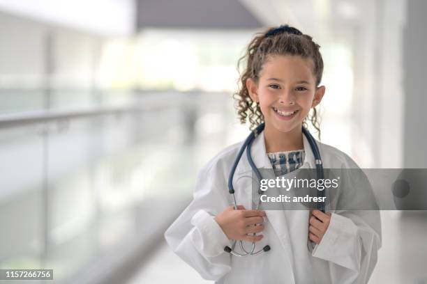 happy girl spelen om een arts te worden in een ziekenhuis - role play stockfoto's en -beelden