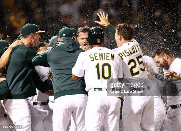 Matt Chapman of the Oakland Athletics is congratulated by teammates after he hit a walk-off home run to beat the Tampa Bay Rays at Ring Central...