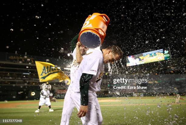 Matt Chapman of the Oakland Athletics is dumped with water by Matt Olson after Chapman hit a walk-off home run to beat the Tampa Bay Rays at Ring...