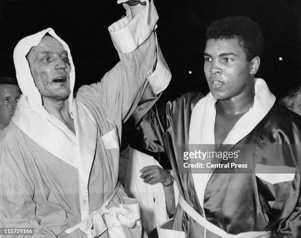 British Heavyweight champion Henry Cooper with American boxer Cassius Clay after their non-title fight at Wembley Stadium, London, 18th June 1963....