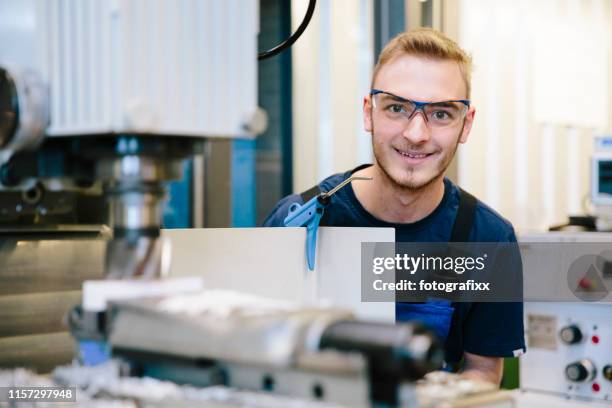 portrait : le jeune technicien avec des lunettes protectrices travaille à une machine de fraisage - engineer cad photos et images de collection