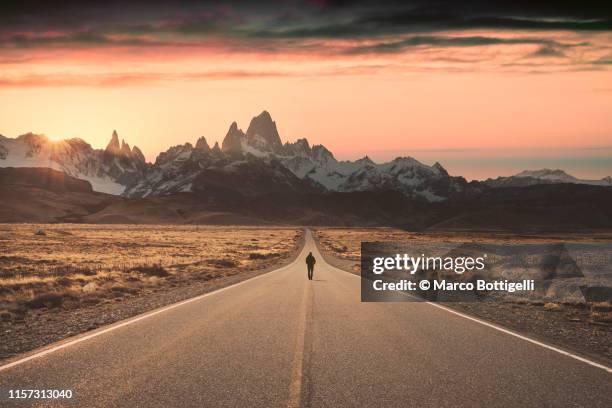 man walking alone on the road to fitz roy, patagonia argentina - two lane highway fotografías e imágenes de stock