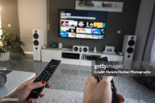 man and woman with television remote control - relatieproblemen stockfoto's en -beelden