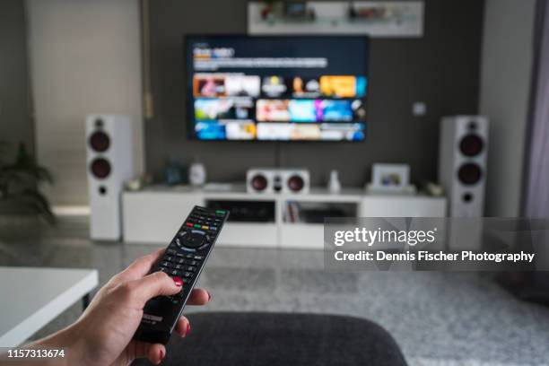 remote control with television in living room - surround sound stock pictures, royalty-free photos & images