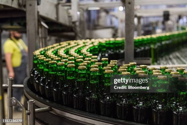 Sealed green Stella Artois lager beer bottles pass along a conveyor at the Anheuser-Busch InBev NV brewery in Leuven, Belgium, on Wednesday, July 17,...
