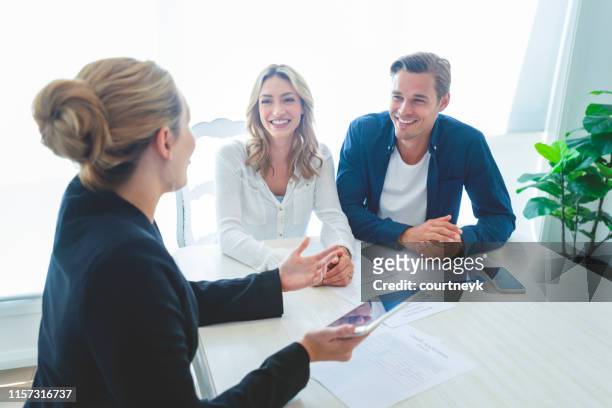 insurance agent with couple looking through documents. - happy customer stock pictures, royalty-free photos & images
