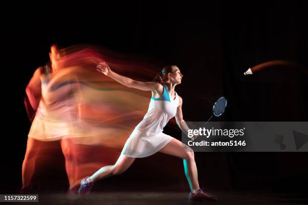 young woman playing badminton isolated on black studio background - beauty shot of young woman stock pictures, royalty-free photos & images