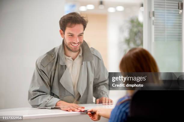 jeune homme achetant des billets - hygiaphone photos et images de collection