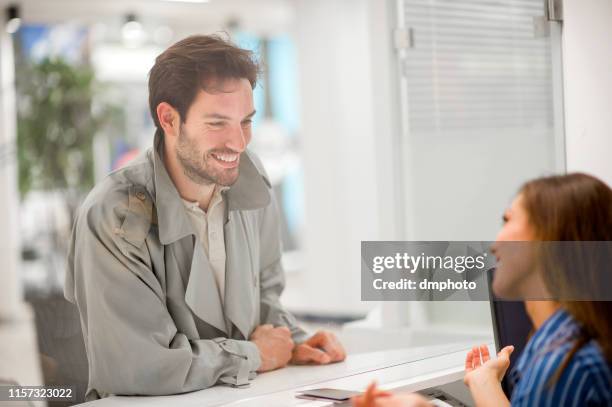 joven comprando entradas - ticket counter fotografías e imágenes de stock