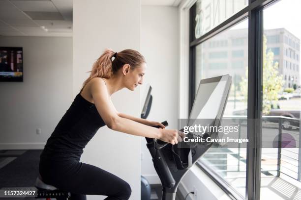 woman working out on exercise bike in workout room - oval room stock pictures, royalty-free photos & images