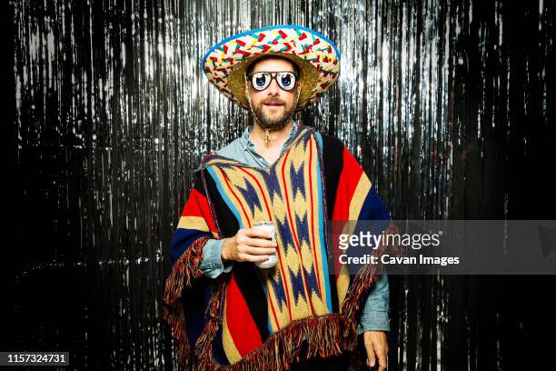 man wearing mexican themed party costume and funny glasses - cinco de mayo stock-fotos und bilder