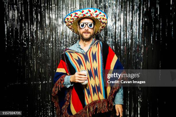 man wearing mexican themed party costume and funny glasses - sombrero hat stock pictures, royalty-free photos & images