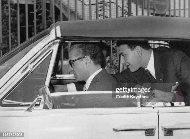 Mohammad Reza Pahlavi , Shah of Iran, driving a Lincoln Continental convertible during a visit to Rome, 25th May 1961. With him is his son-in-law,...