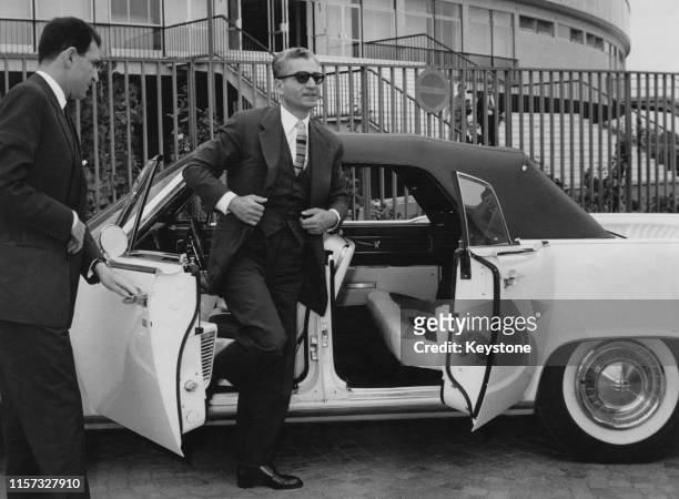 Mohammad Reza Pahlavi , Shah of Iran, driving a Lincoln Continental convertible during a visit to Rome, 25th May 1961. With him is his son-in-law,...