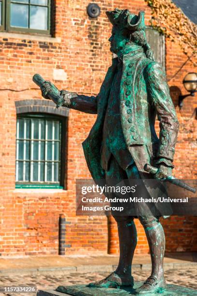 statue of captain george vancouver against the backdrop of a old warehouse, purfleet quay, king's lynn, west norfolk, england, uk. - king's lynn stock pictures, royalty-free photos & images