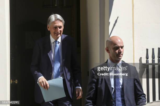 Philip Hammond, U.K. Chancellor of the exchequer, left, departs from number 11 Downing Street following a meeting of cabinet ministers in London,...