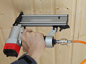 Air Nailer, Stapler pneumatic work with hand controls. Carpenter fix clapboard