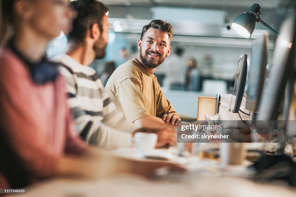 Happy Computer Programmers Communicating While Working On Desktop Pcs ...