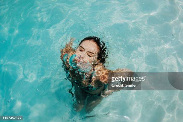 young woman coming up from being submersed underwater - schönheit frau wasser gesicht stock-fotos und bilder