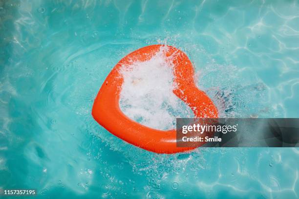 splash and spray through heart shaped inflatable - floating on water stock pictures, royalty-free photos & images