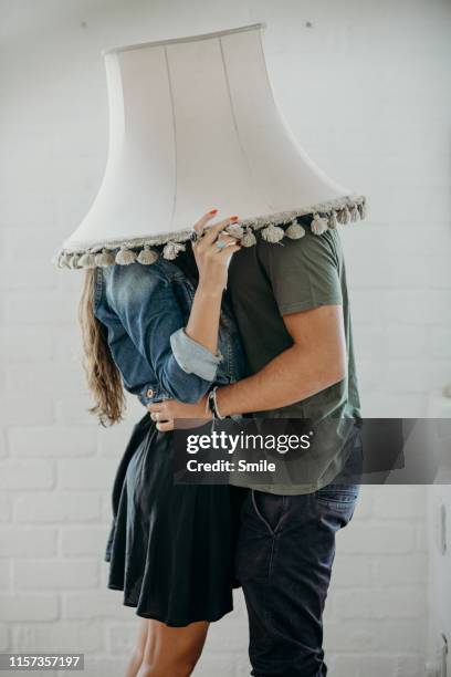 couple finding privacy to kiss under lampshade - secluded couple stockfoto's en -beelden