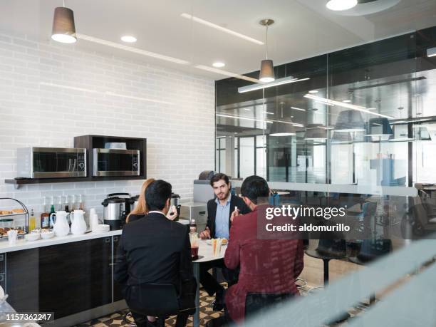 colleagues taking  a lunch break in the cafeteria - workplace canteen lunch stock pictures, royalty-free photos & images