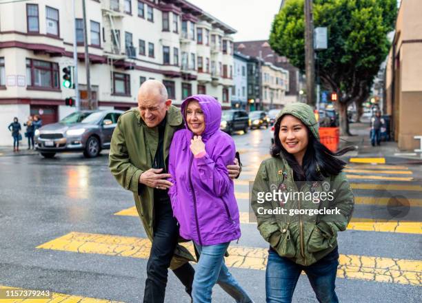 nog steeds glimlachend tijdens het oversteken van de straat in de regen-san francisco - still life stockfoto's en -beelden