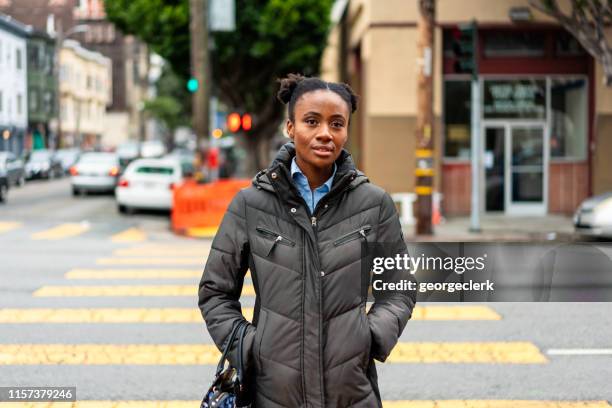 mujer cruzando la calle en san francisco, california - winter coat fotografías e imágenes de stock