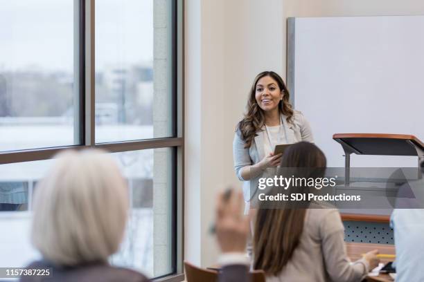 teacher takes question from class member about digital tablets - inclusive classroom stock pictures, royalty-free photos & images