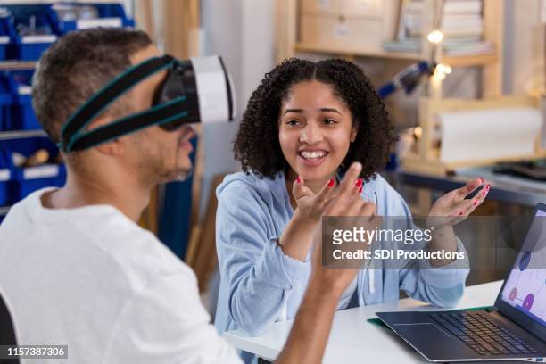 as he gestures, teen girl wonders what dad sees in virtual reality - virtual showing stock pictures, royalty-free photos & images
