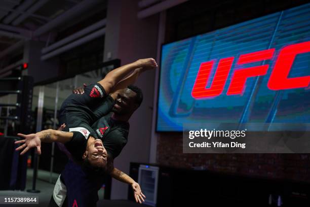 Fighter Uriah Hall lifts Jessica Andrade up after workout session during Fan Experience at UFC Performance Institute on June 21, 2019 in Shanghai,...