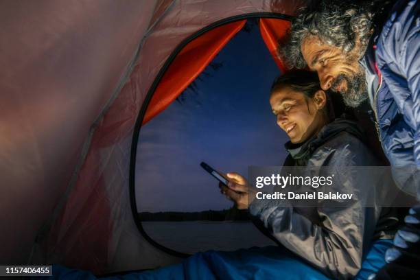 happy couple turister camping och göra en läger elden i naturen. äventyr överlevande utomhus i vildmarks området. - entertainment tent bildbanksfoton och bilder