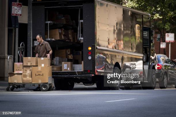 United Parcel Service Inc. Delivery driver places packages on a dolly to be delivered in Chicago, Illinois, U.S., on Monday, July 22, 2019. UPS is...