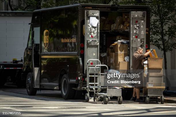 United Parcel Service Inc. Delivery driver places packages on a dolly to be delivered in Chicago, Illinois, U.S., on Monday, July 22, 2019. UPS is...