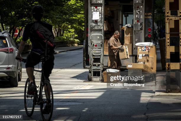 United Parcel Service Inc. Delivery driver places packages on a dolly to be delivered in Chicago, Illinois, U.S., on Monday, July 22, 2019. UPS is...