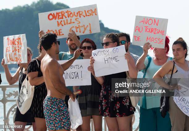 Tourist speaks with protesters that demonstrate against the shooting of Woody Allen's new film in the Spanish Basque city of San Sebastian on July...