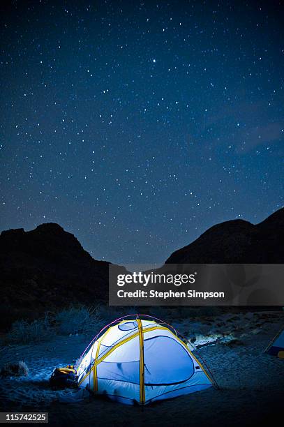 small glowing tent and desert night sky - camping night stock pictures, royalty-free photos & images
